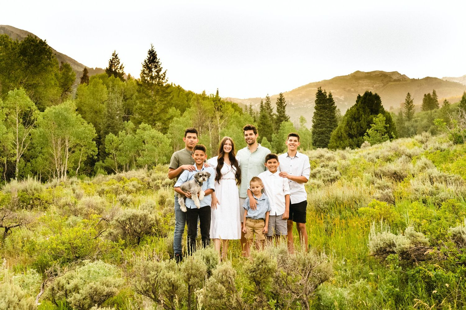 Group photos taken in a scenic mountain landscape with lush green vegetation.