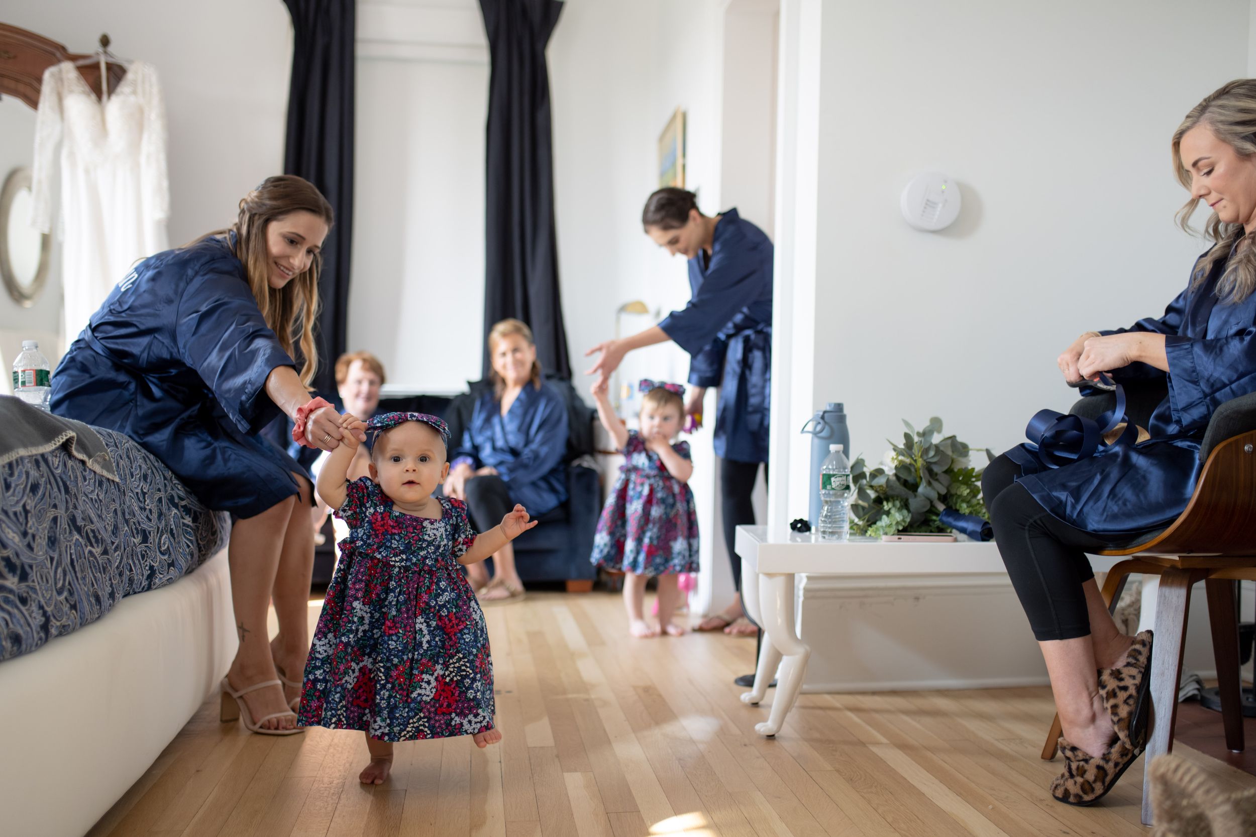 Children and adults playing together in a bright room with hardwood floors.