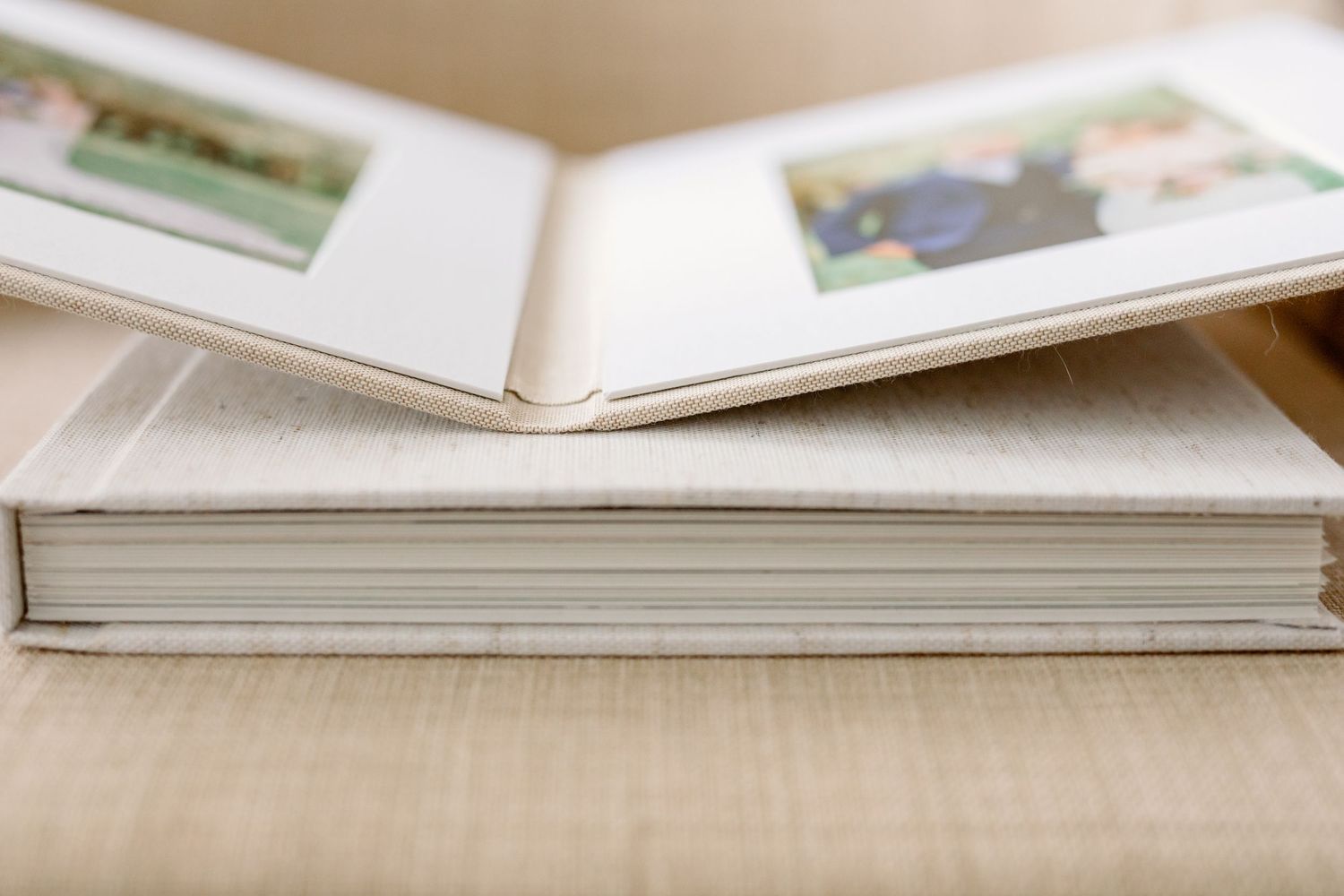 A close up of an open photo album lying on top of a closed one.