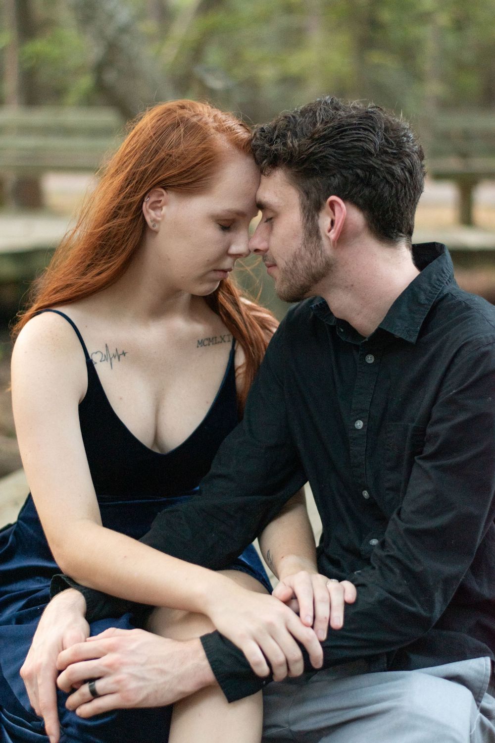 An intimate moment between a couple in formal wear sitting close together outdoors.