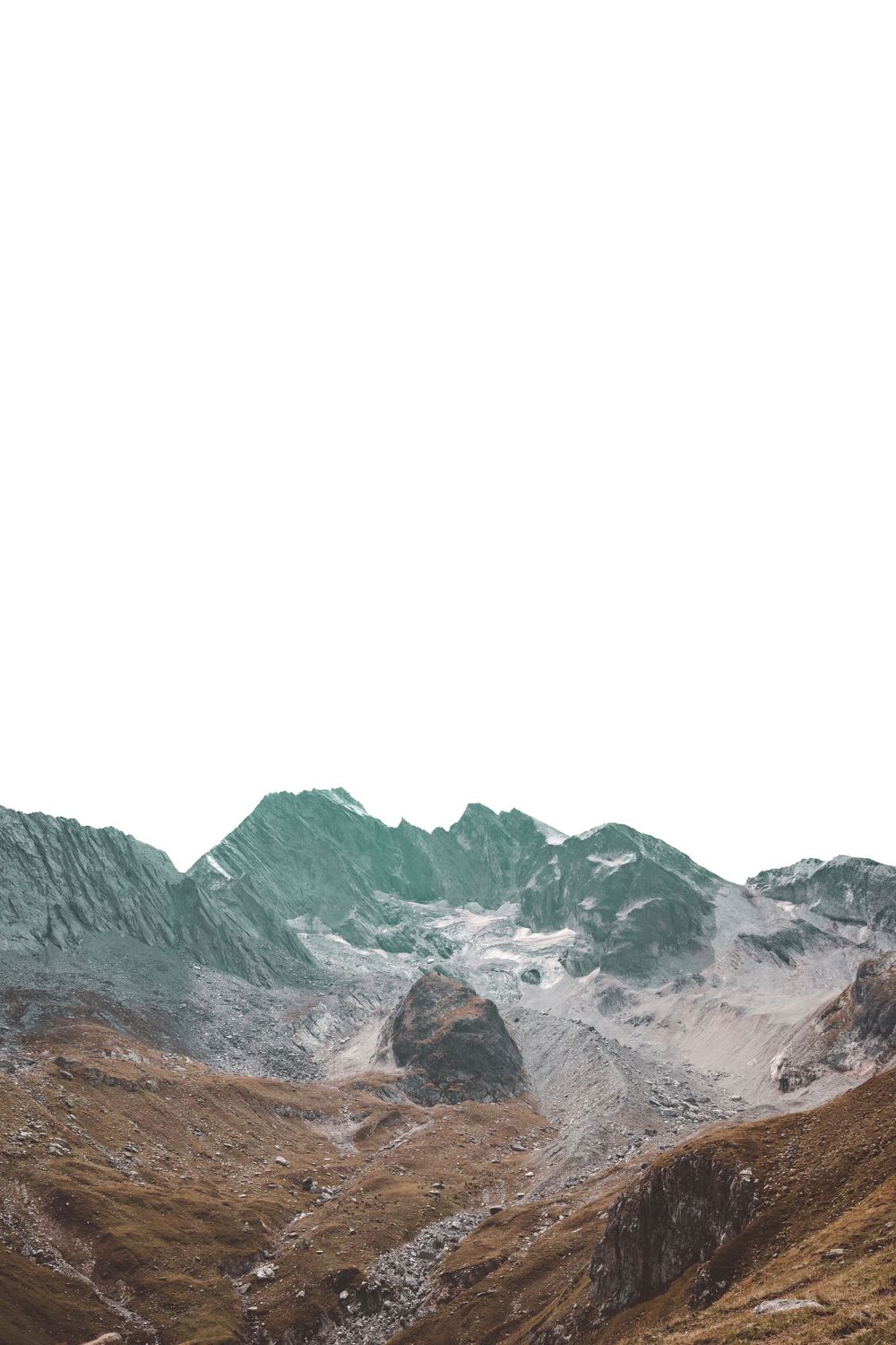 Rugged mountain landscape with snow-covered peaks against a white sky.