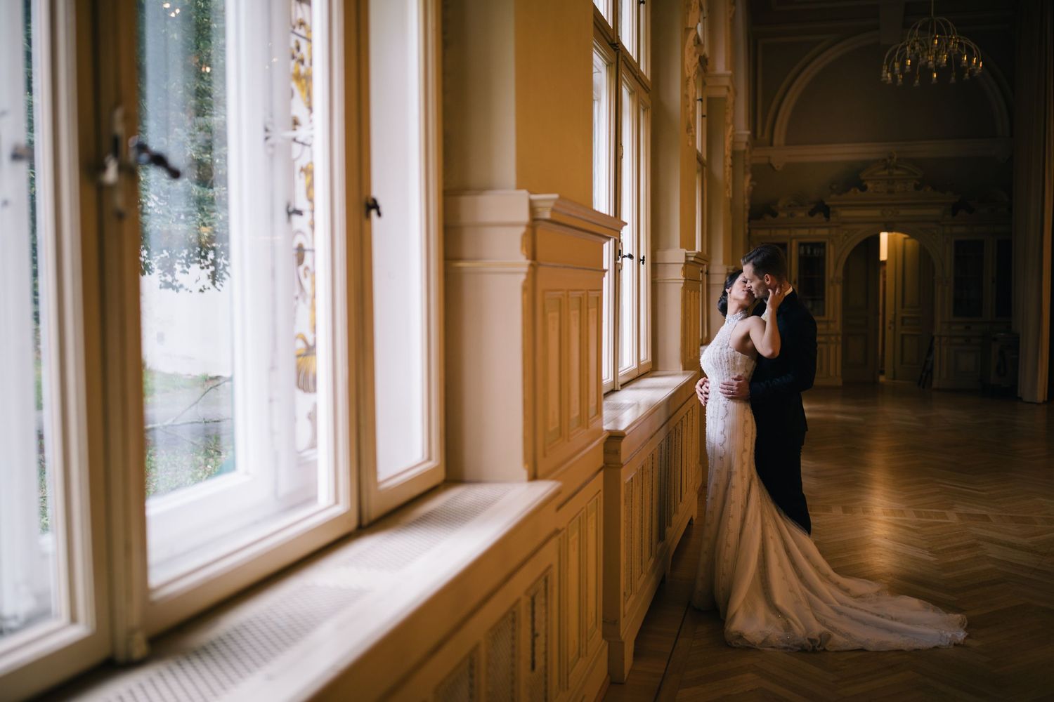 Hochzeitsfotografie - Brautpaar in enger Pose im Schloss am Fenster in Rothenburg ob der Tauber Wildbad