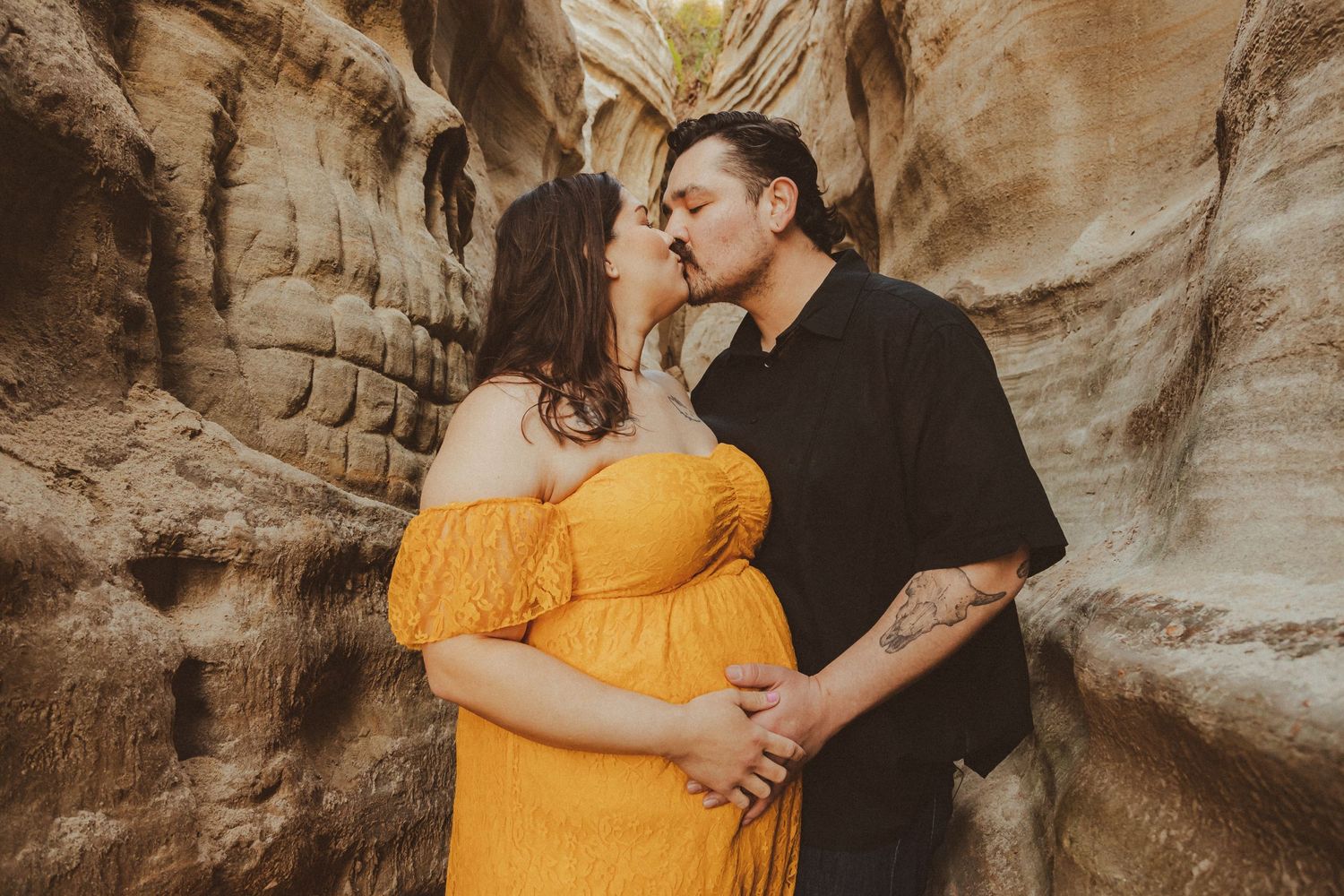 Couple sharing an intimate moment between sandstone canyon walls.