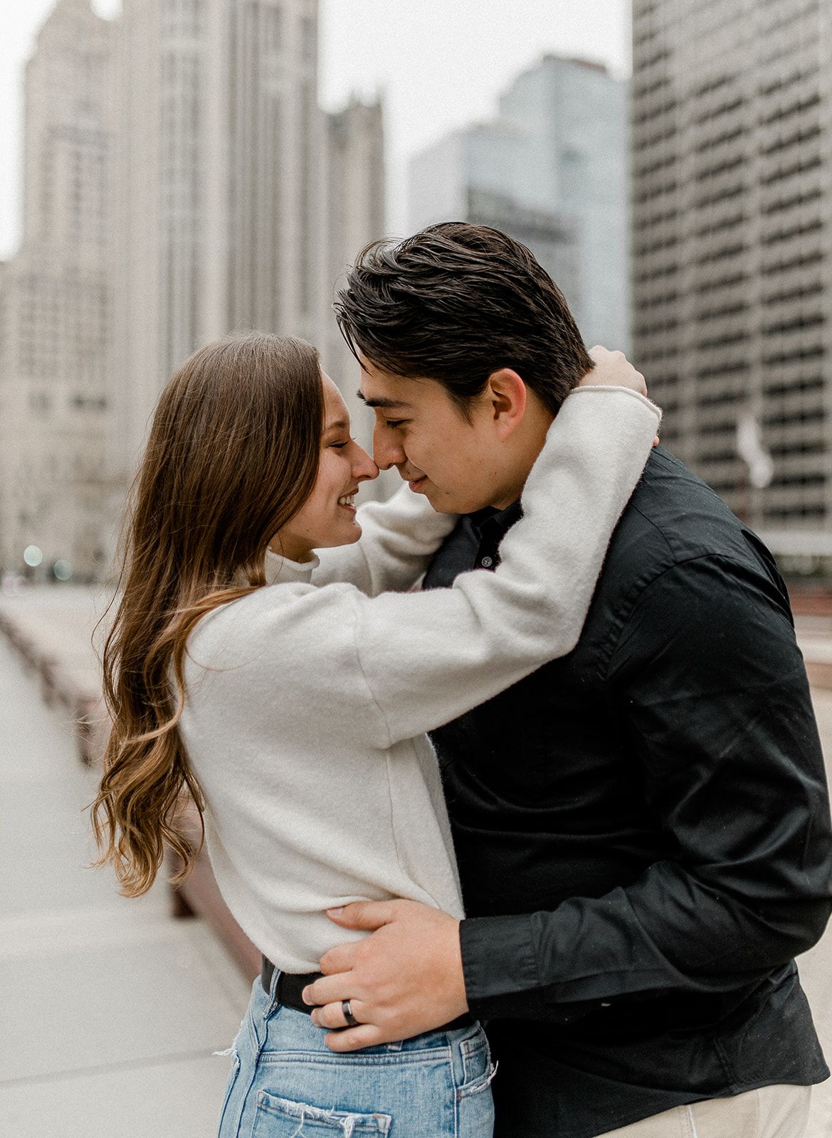 Intimate couple moment with urban architecture backdrop as they share a tender embrace.