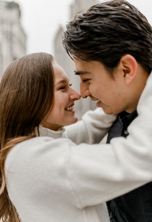 Close up of couple sharing tender moment against blurred city backdrop.