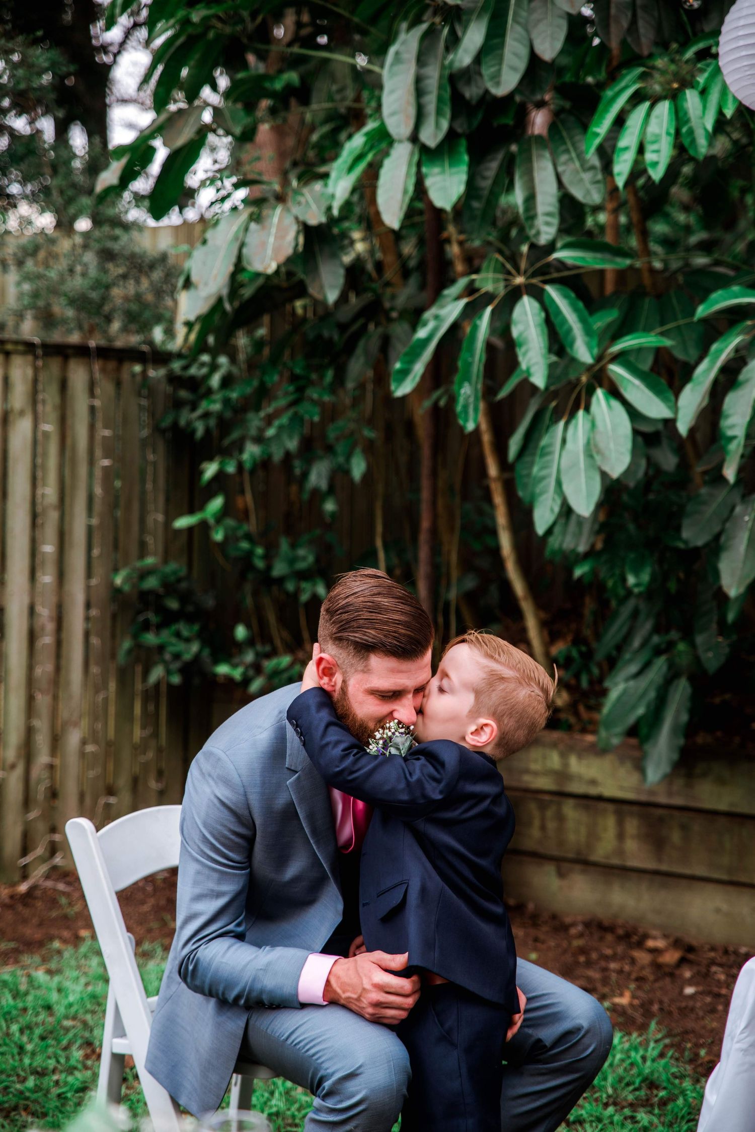 A sweet embrace shared between two people at an intimate garden wedding ceremony.