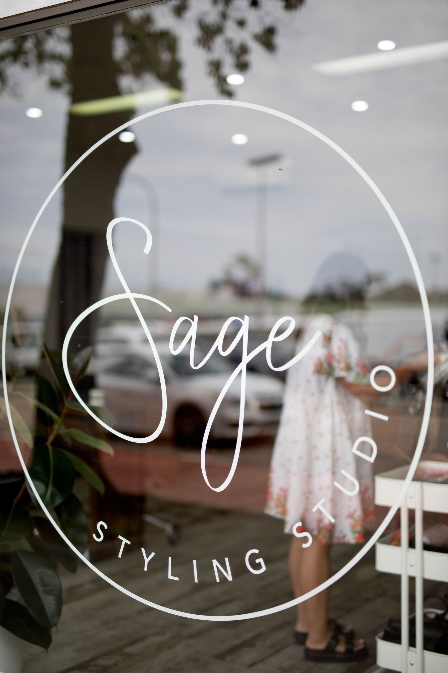 Sage Styling Studio logo design displayed on a storefront window with elegant cursive lettering.