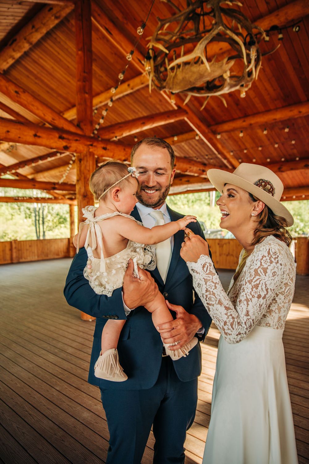 Couple with a little girl, smiling and in wedding attire