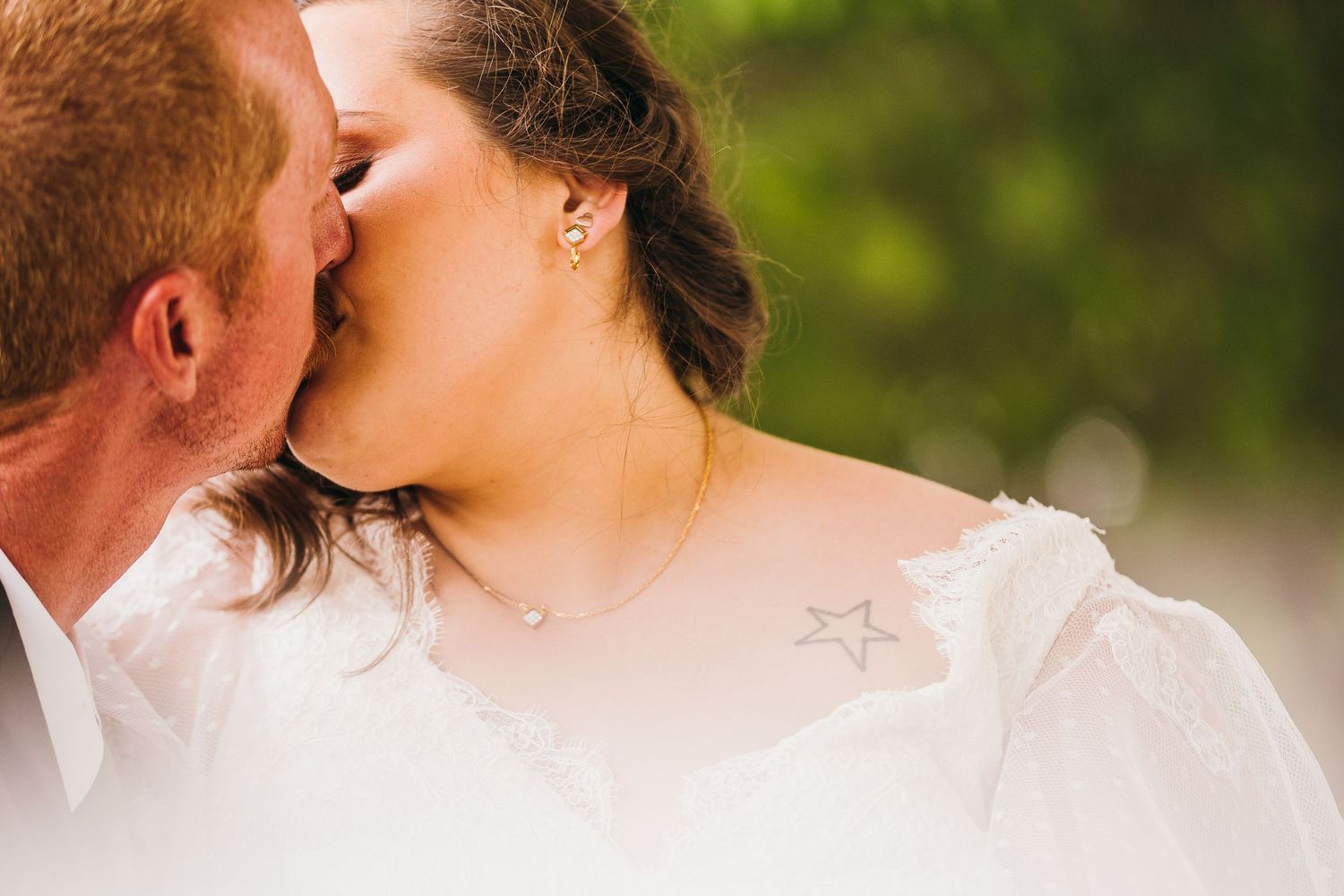 Intimate close-up of a romantic kiss between newlyweds outdoors.
