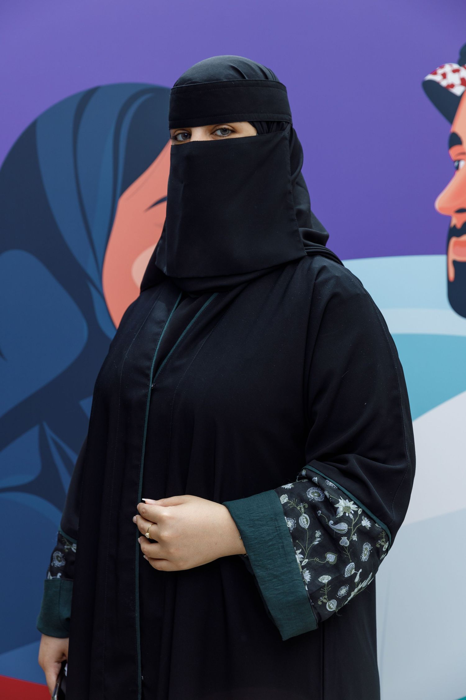 A person wearing a traditional black niqab and abaya against a purple and blue background.