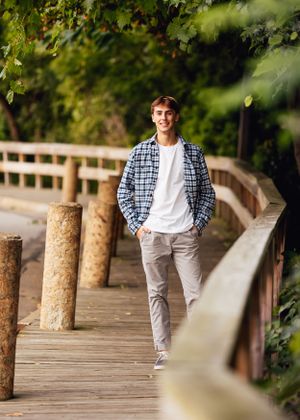 senior boy standing on boardwalk portrait