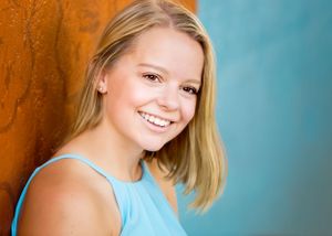 senior girl in blue dress smiling for portrait