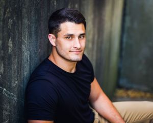 college senior boy sitting on stairs in black tee shirt