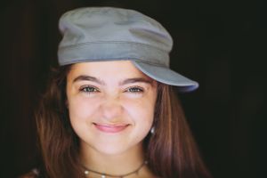 girl in hat scrunching nose