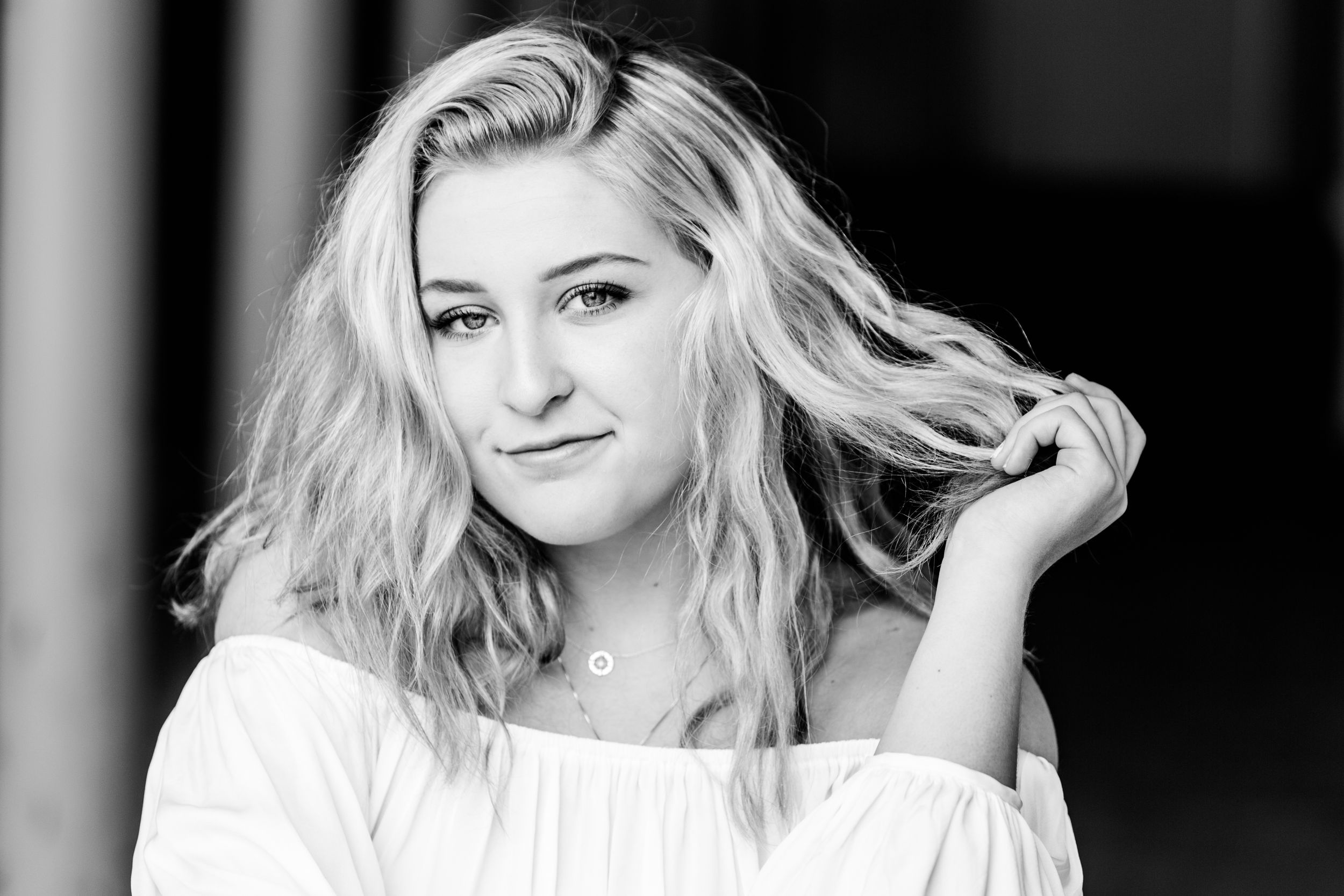 black and white of senior girl pulling hair to side