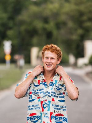 high school senior boy in Pepsi shirt fixing collar