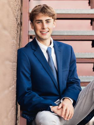 Senior boy on stairs with blue jacket and tie