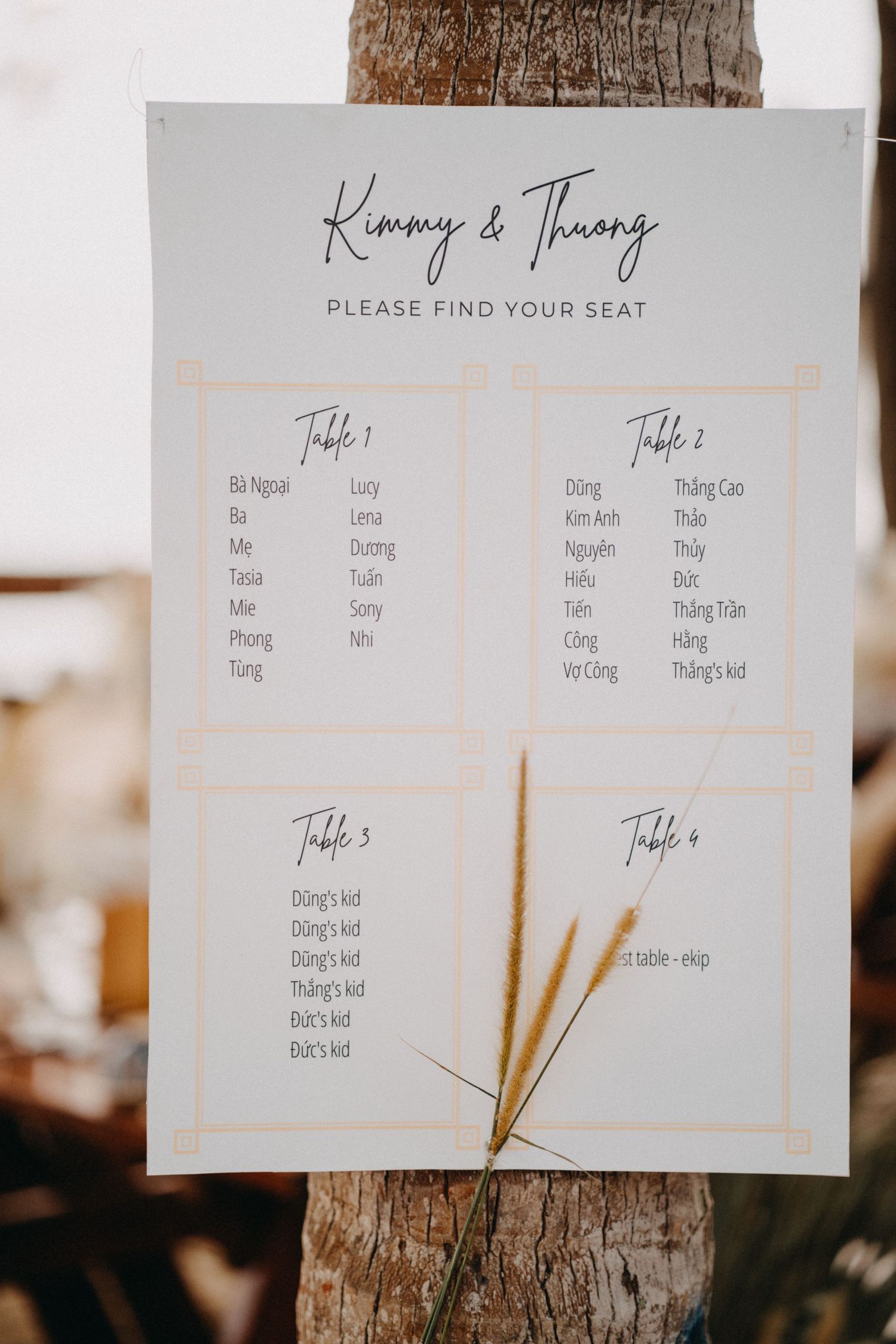 Wedding seating chart for Kimmy and Thuong displayed on a palm tree.
