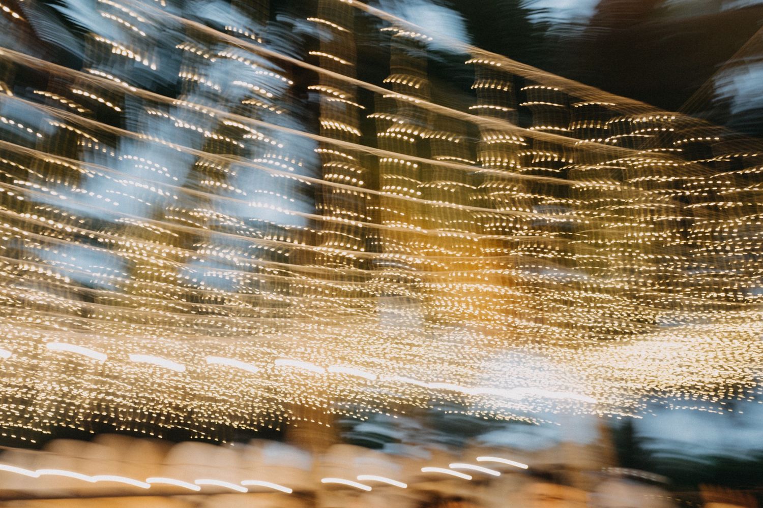 Abstract blurred bokeh of golden string lights at outdoor wedding venue.