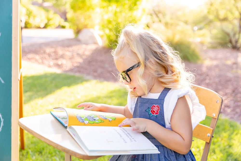 Student studying at outdoor desk with books during golden hour.