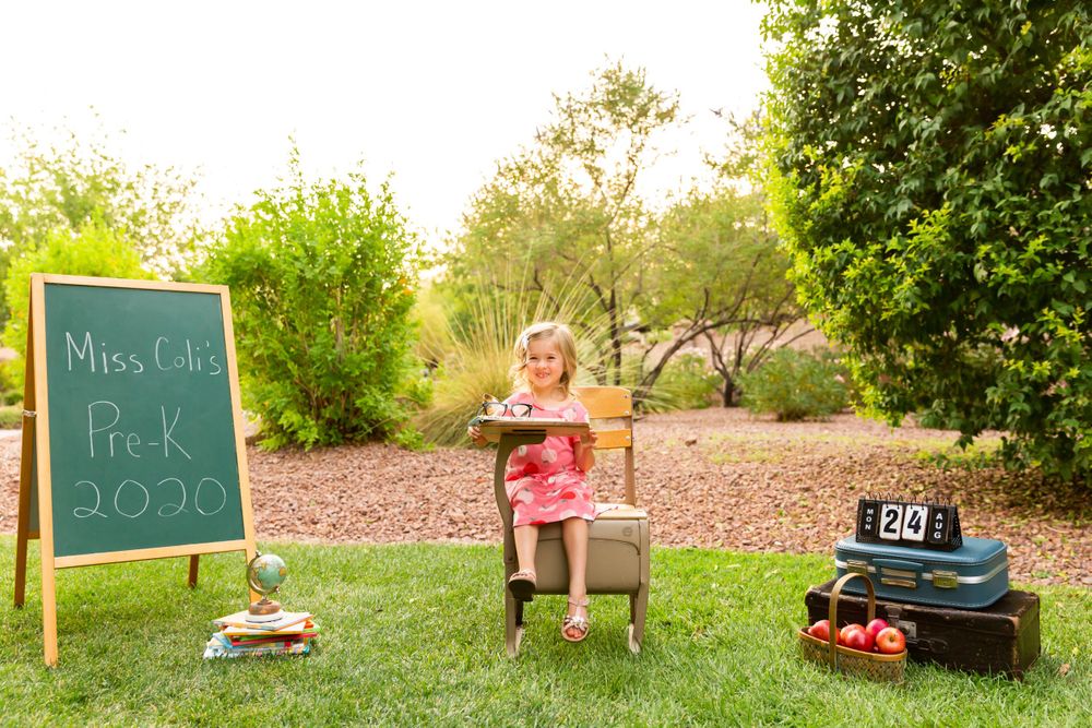 Pre-K 2020 back to school setup with chalkboard, desk, and props in a garden setting.