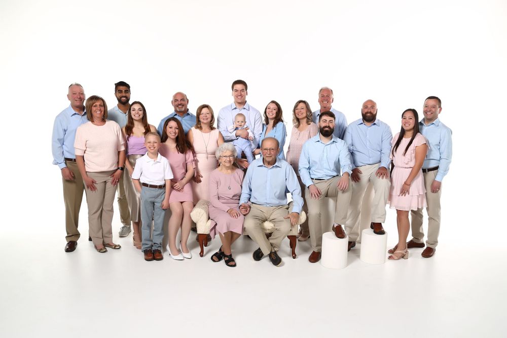 Large diverse group in business casual attire poses together against white background.