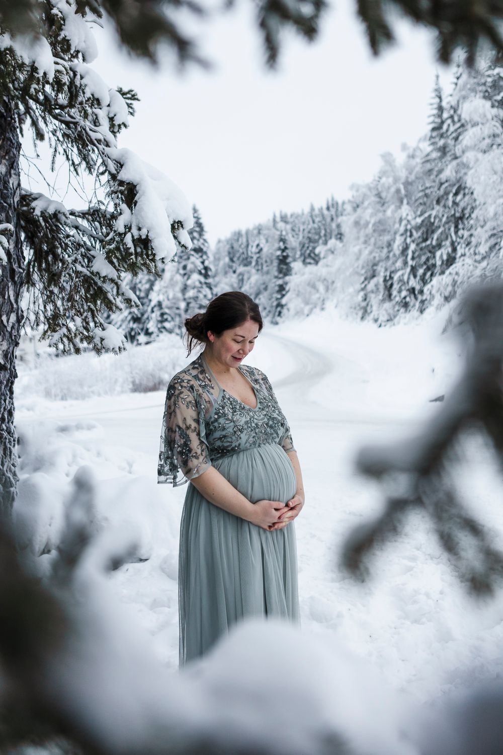 Gravid kvinne ute i snøen med glinsende tyllkjole