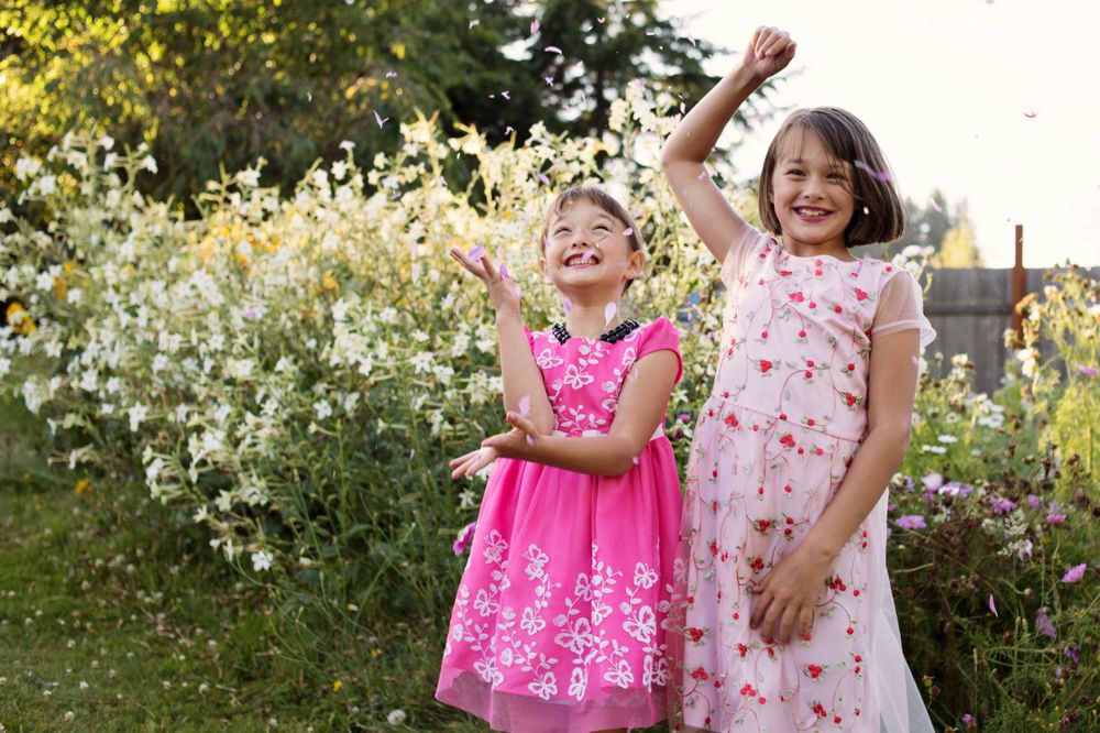 Two girls throwing flower petals