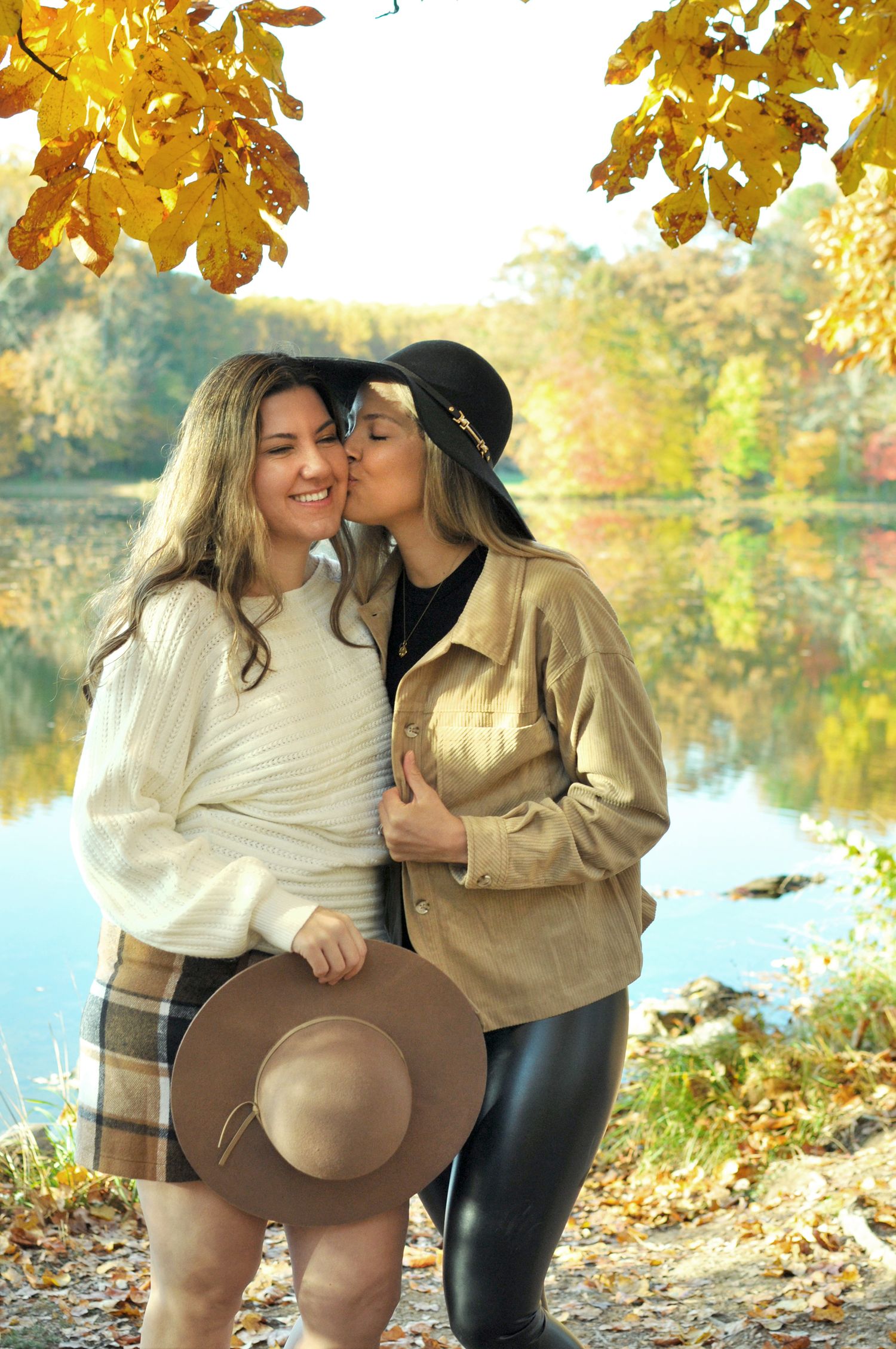 Couple kissing on cheek near lake fall photo session