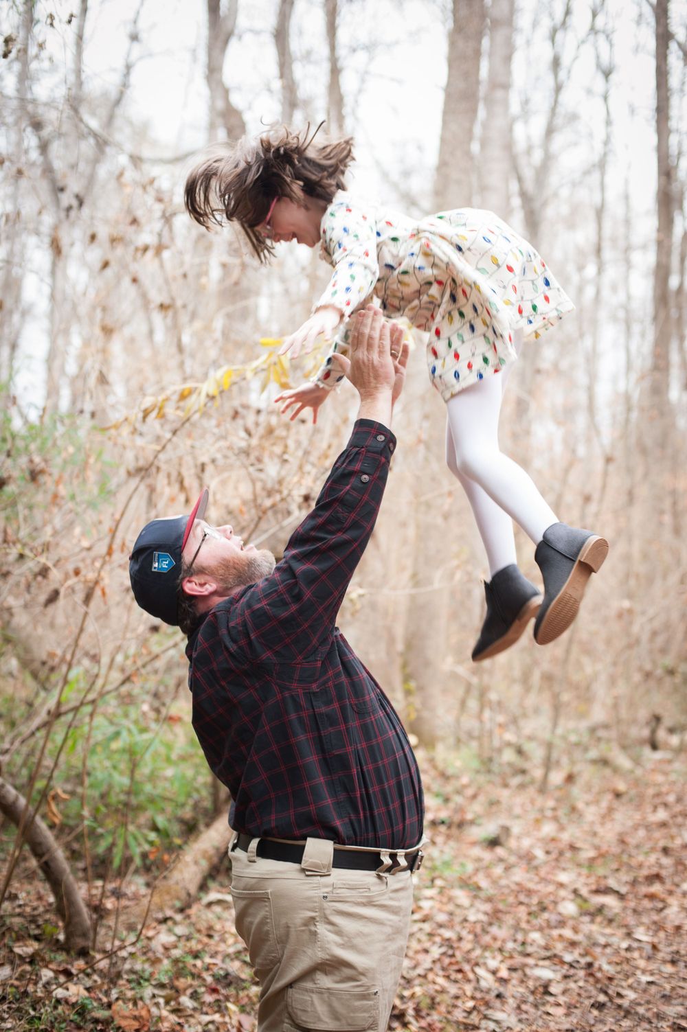 A playful moment captured in autumn woods with leaves falling around.