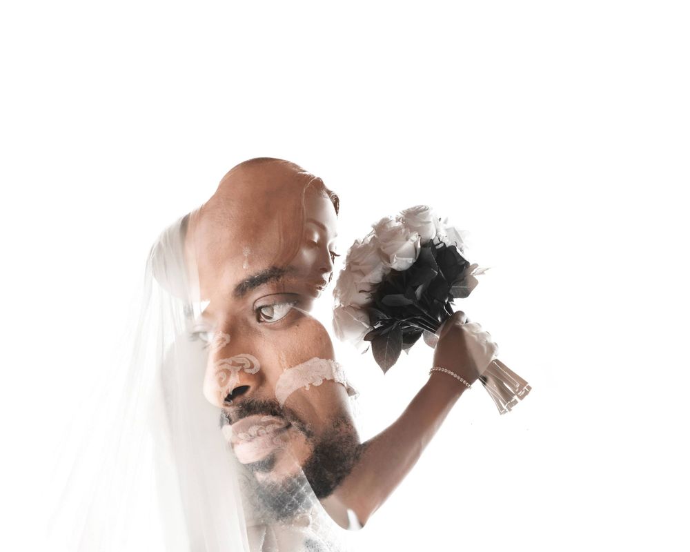 A dramatic bridal portrait with a black and white bouquet against a white background.