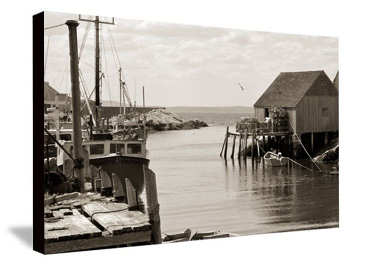 Vintage black and white photograph of fishing boats docked at a harbor with wooden buildings on stilts.