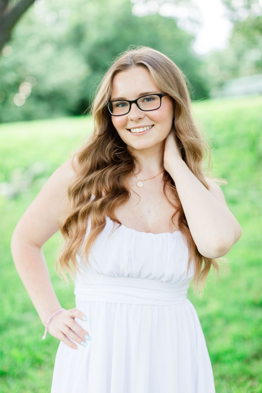 Portrait in white dress against blurred green natural background.