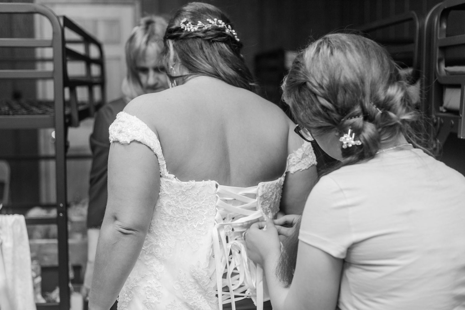 Black and white photo of bridesmaids in elegant dresses from behind.