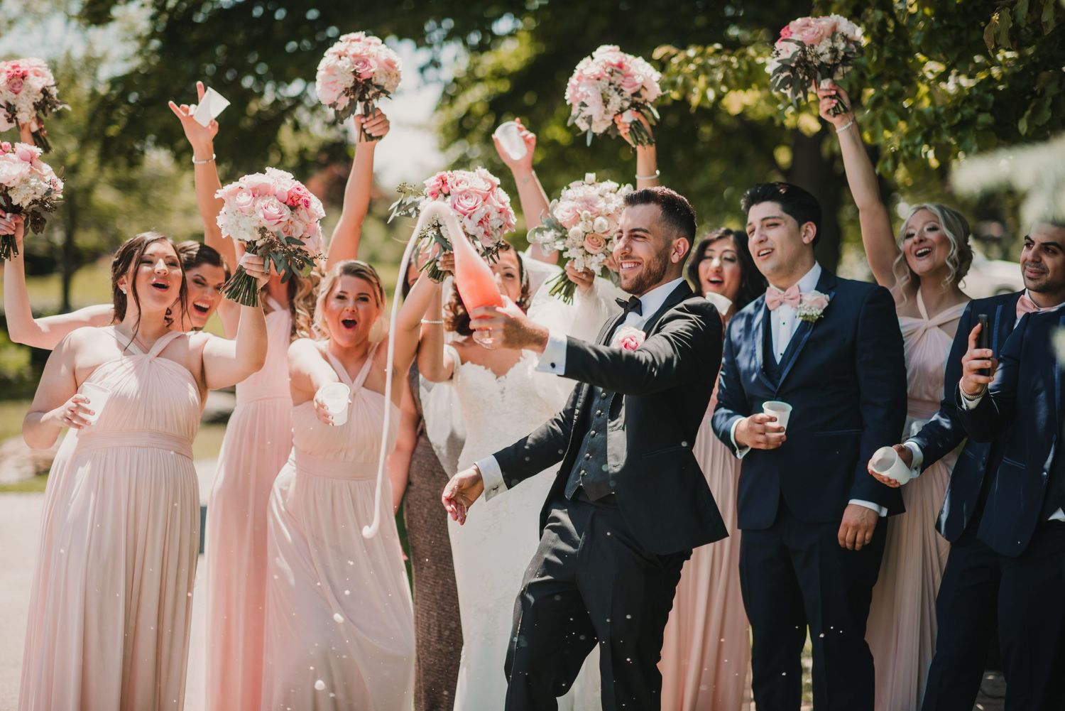 bridal party popping champagne