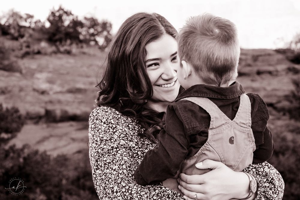 Black and white candid portrait capturing laughter and joy outdoors.