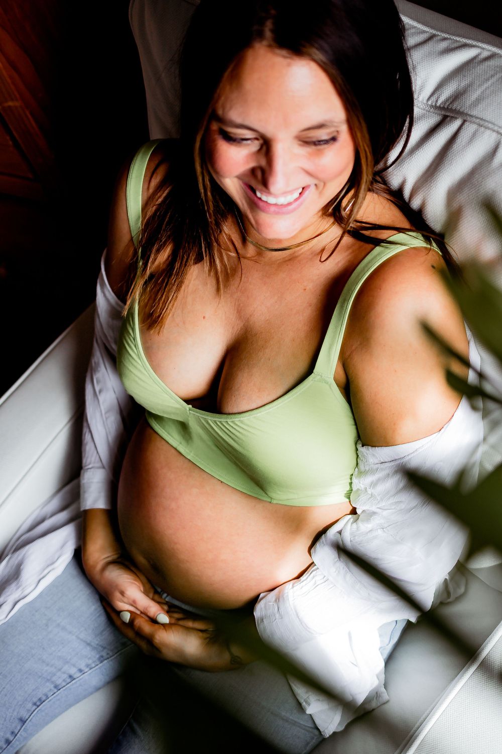 Maternity portrait showing joyful expression in mint green loungewear. Denver Family Photography.
