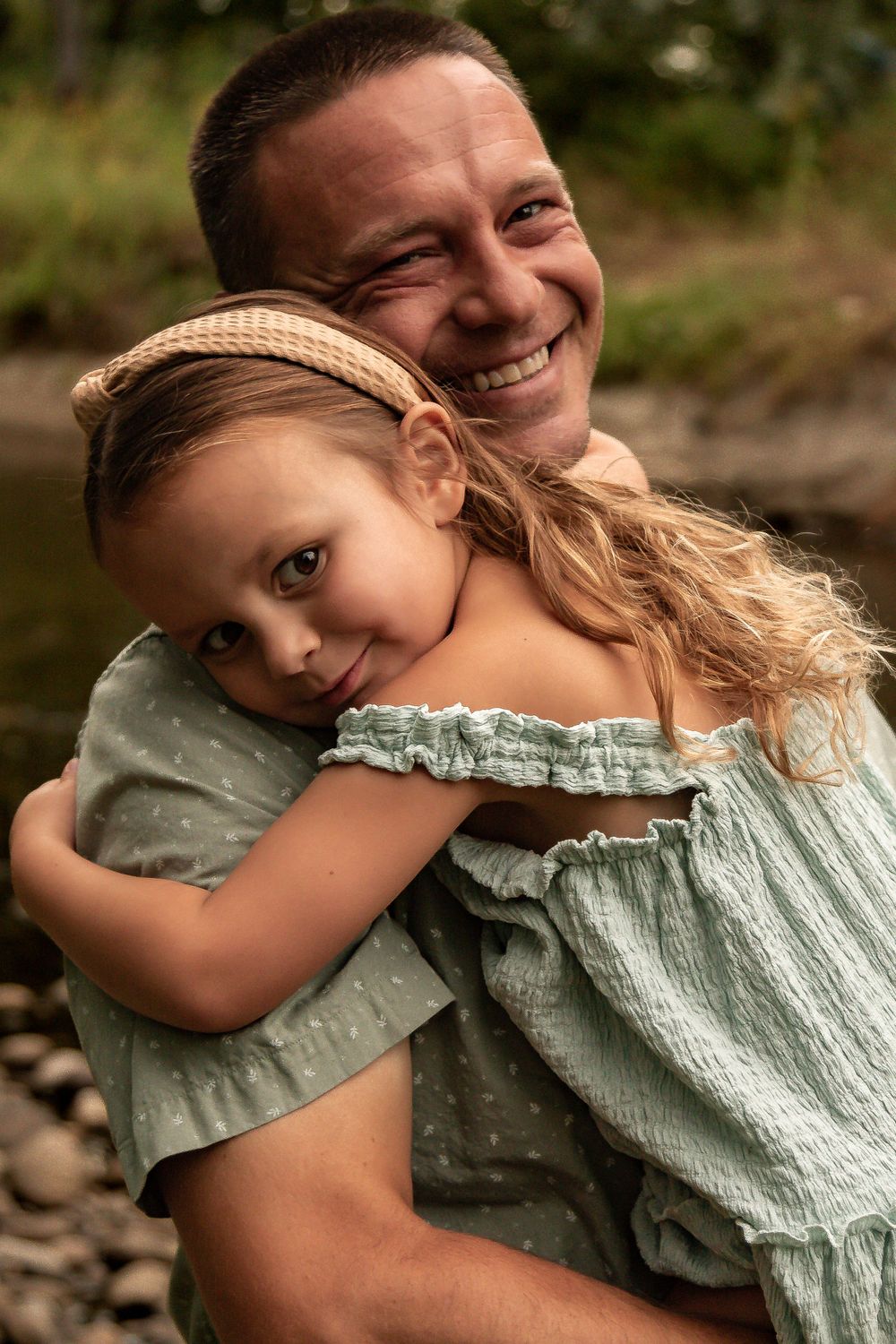 A touching moment between parent and child by a riverside. Denver Family Photography.