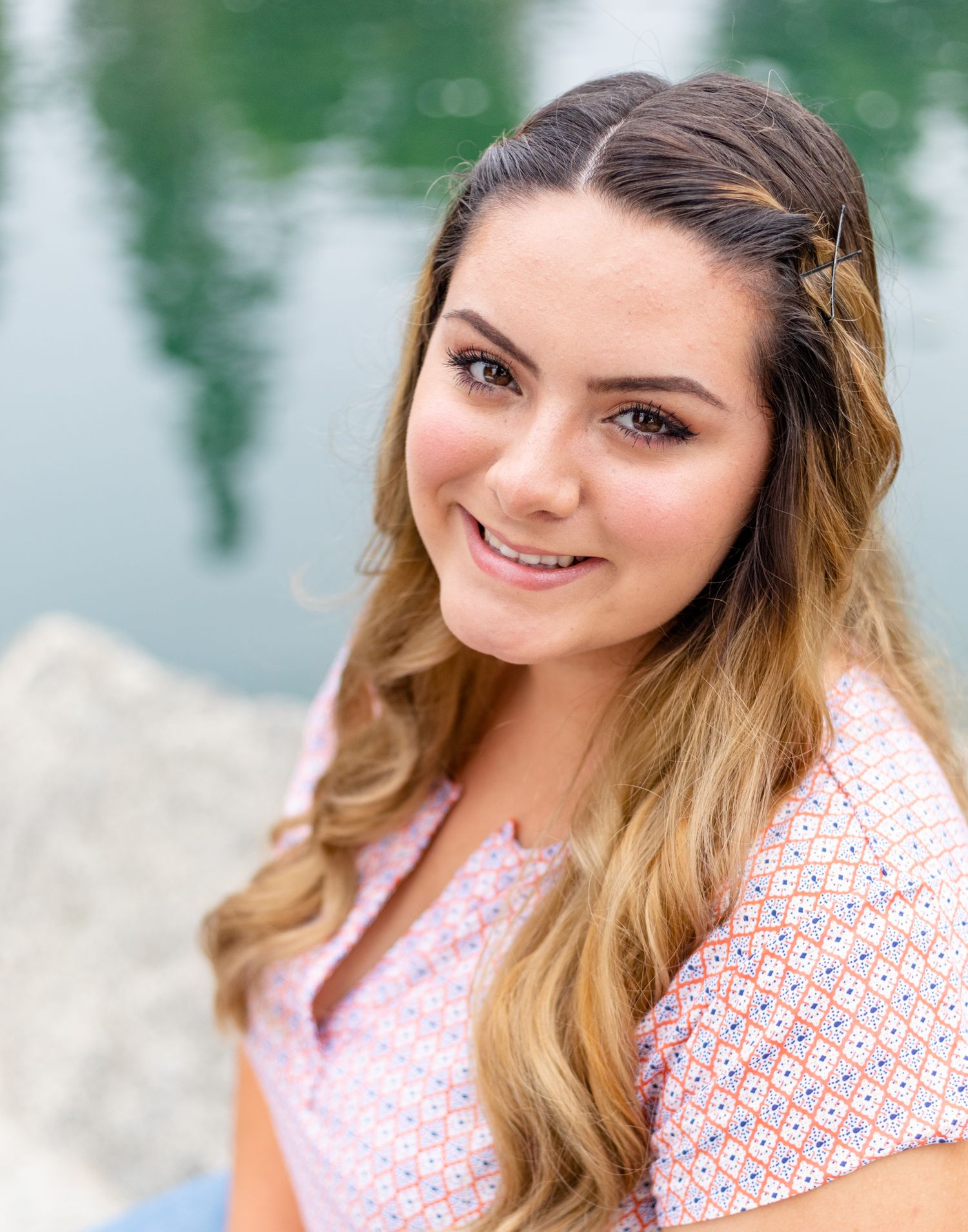 Young girl sitting by lake high school band photo