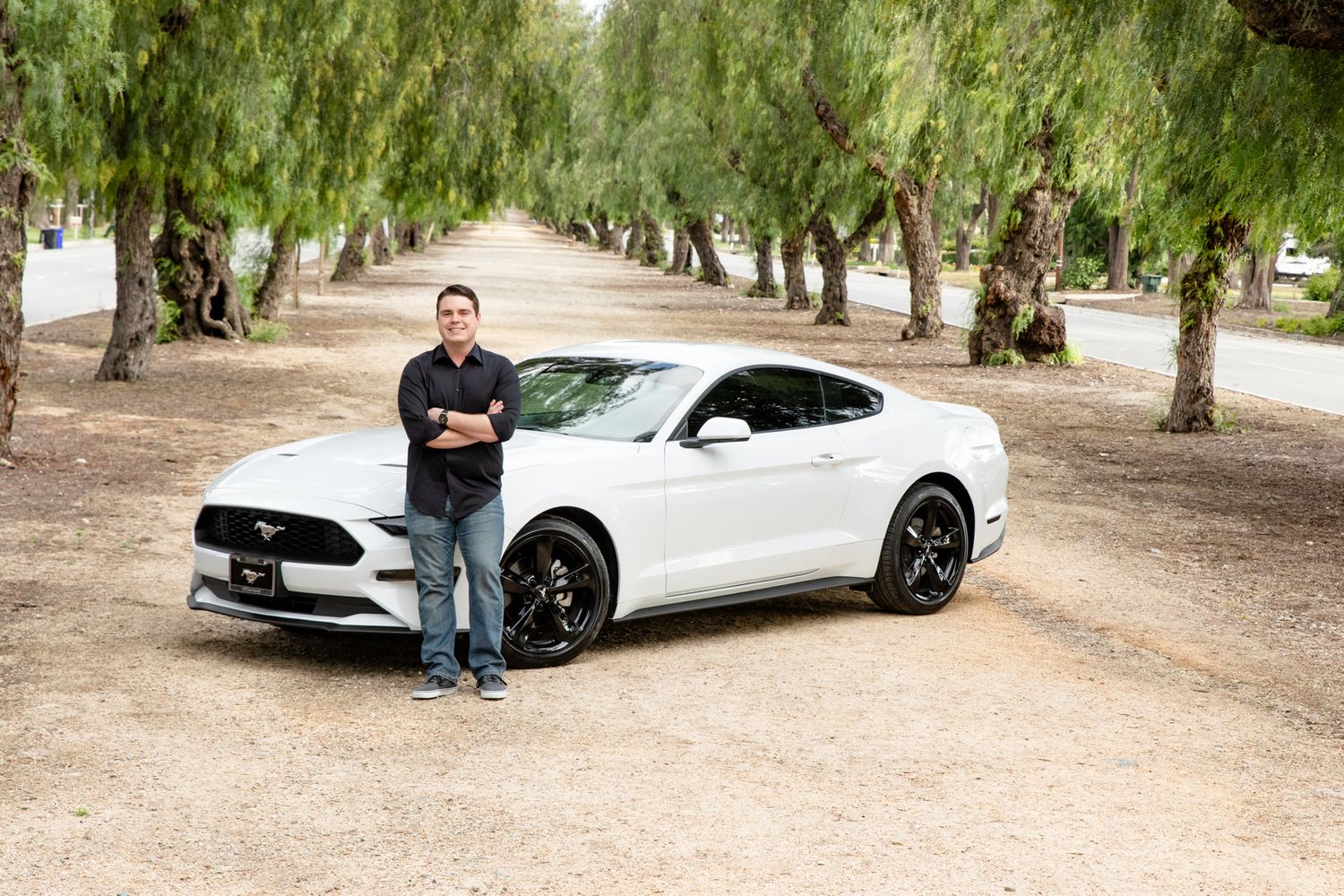 white Ford Mustang with guy and trees