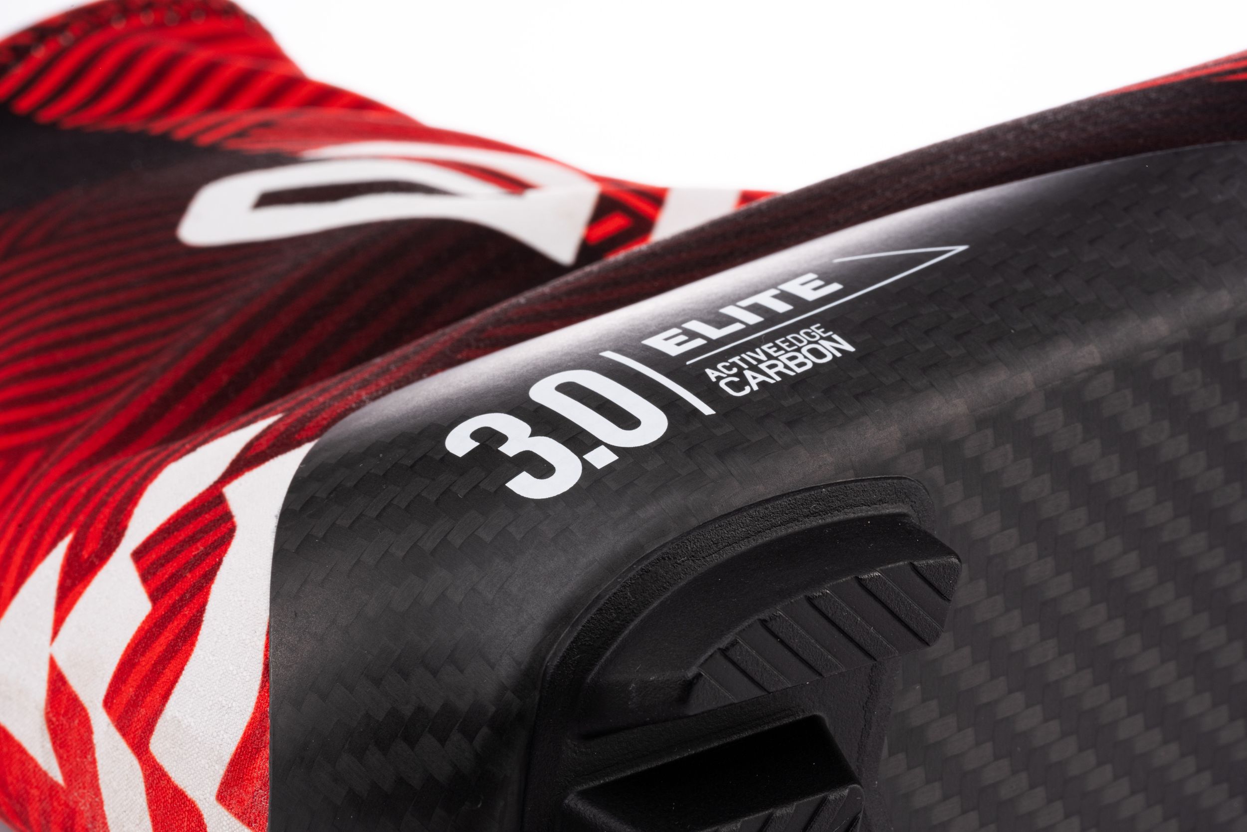 Close-up of red and white racing stripes on a carbon fiber surface.