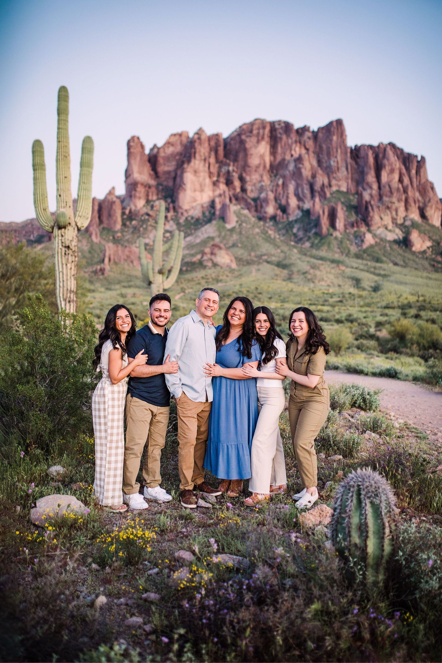 Happy family of six poses together in Arizona desert with Superstition Mountains backdrop.