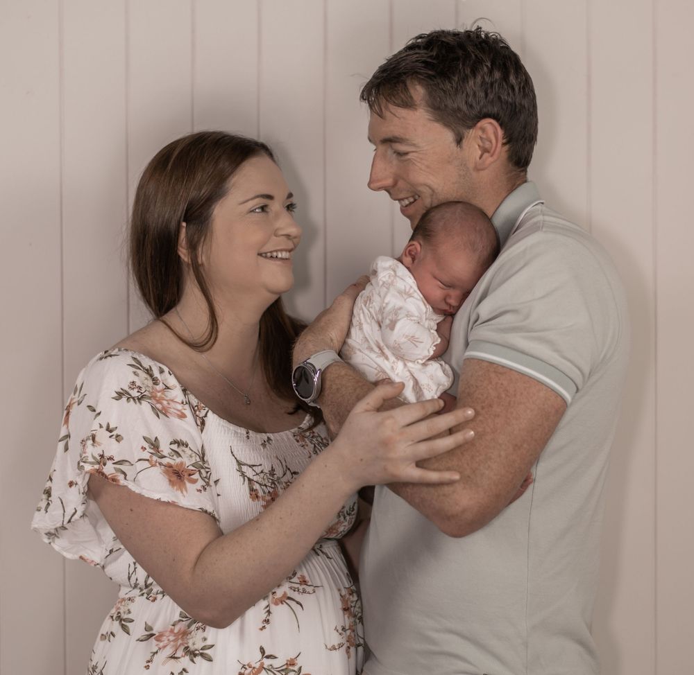 A series of tender moments showing a parent and baby bonding together in a warm, intimate photoshoot.