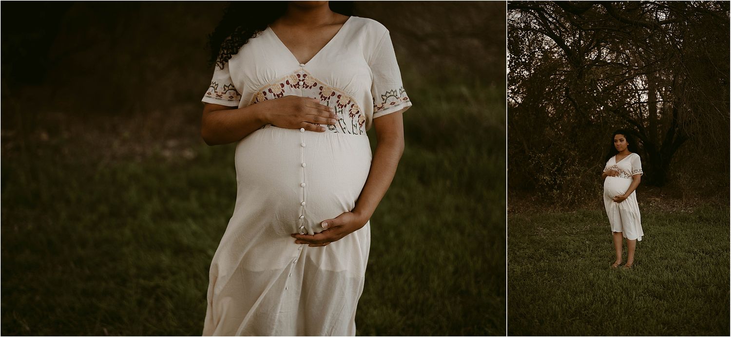 Maternity photos in a white dress against a wooded outdoor setting at dusk.