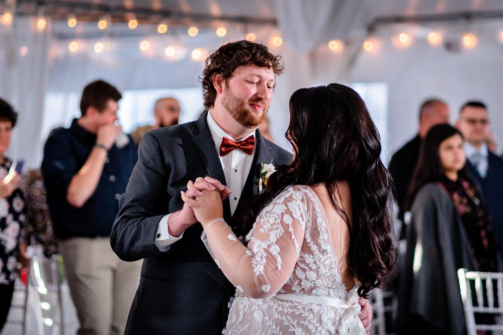 Wedding reception under twinkling lights with guests enjoying the celebration.