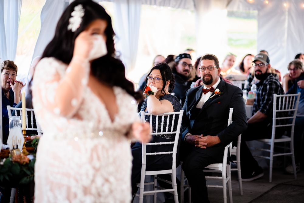 Wedding reception scene with white draping, chiavari chairs and elegant table settings.