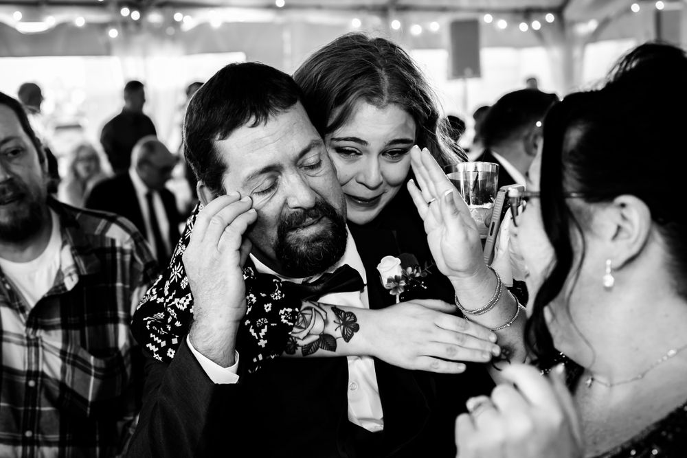 Black and white candid moments from an emotional wedding reception celebration.