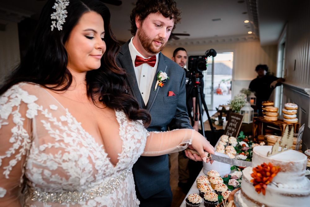 Elegant wedding reception scene with couple enjoying dessert and laughter at a decorated indoor venue.