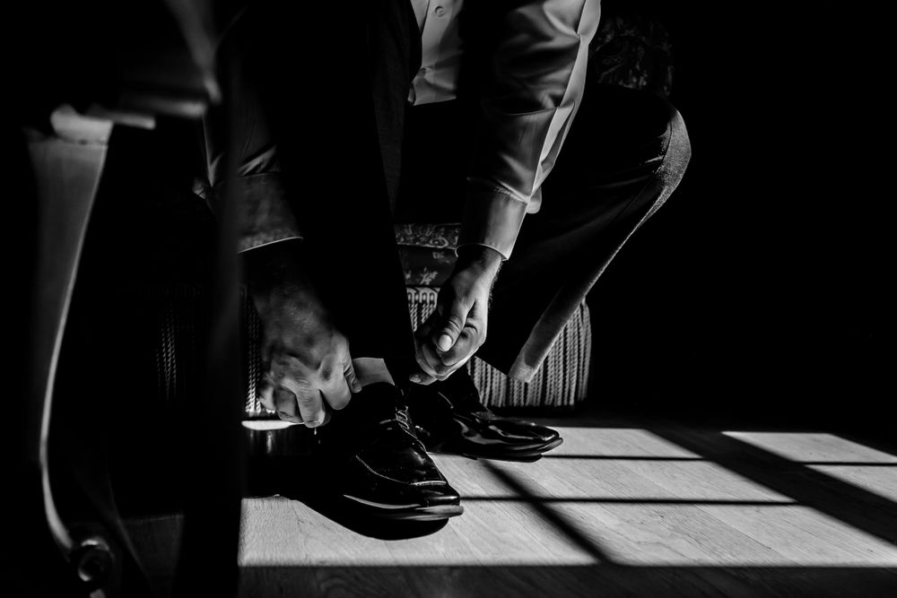 Dramatic black and white composition of hands and shadows on table.