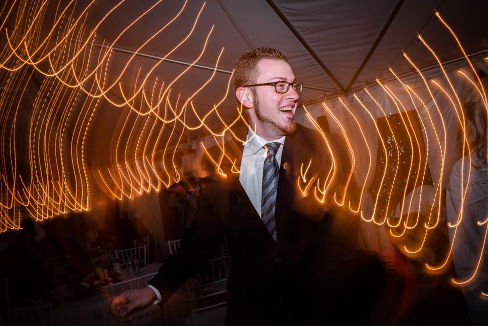 Creative long exposure photography showing light trails and motion at a wedding reception.